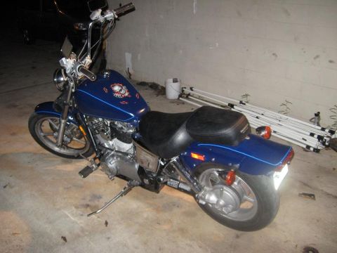 1995 Honda Shadow Sabre VT 1100 - A blue motorcycle is parked on a concrete floor indoors, with some equipment leaning against a wall in the background.