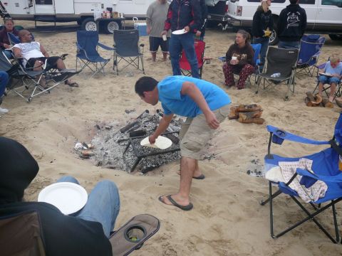 1988 Ford Bronco - People enjoy a beach gathering with an RV and trailer in the background.
