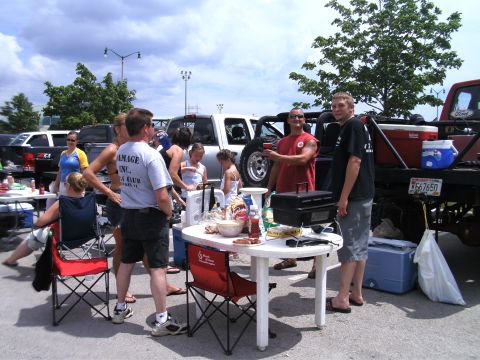1994 Ford F-250 - A group of people enjoy a picnic with multiple trucks parked nearby under a cloudy sky.