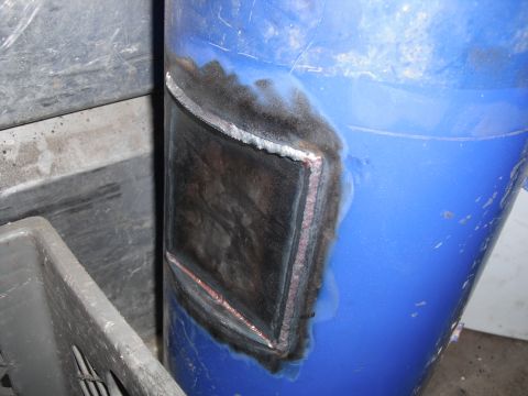 1991 Ford Bronco - A close-up view of a repair patch on a blue cylindrical object, with visible welding and metalwork.