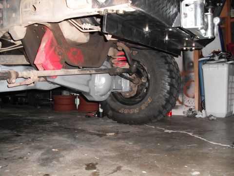 1991 Ford Bronco - Close-up of a vehicle's undercarriage, showing suspension components and a "BIG FOOT" tire.