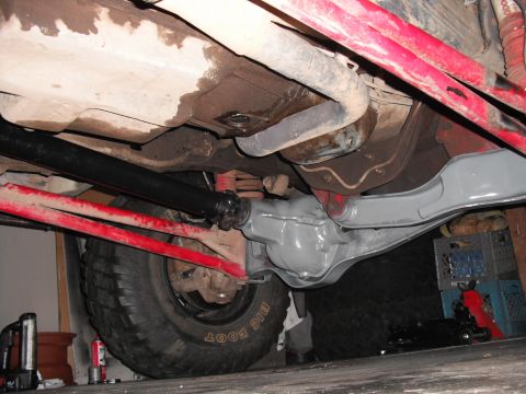 1991 Ford Bronco - The rear axle assembly and driveshaft are visible from underneath the vehicle, showing recent work or modifications.