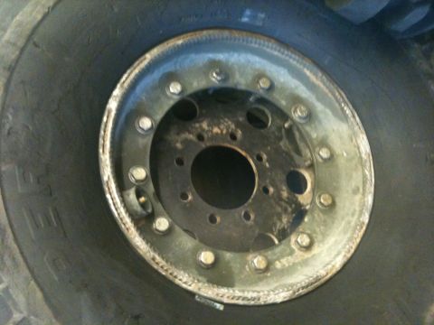 1966 Ford Bronco - This image shows a close-up view of a vehicle's wheel and tire, focusing on the rim and lug nut assembly.