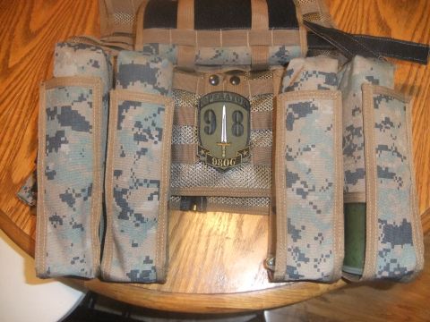 1978 Chevrolet C/K Pickup - Close-up of a military vest with multiple pouches and a unit patch.