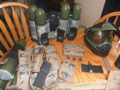 1978 Chevrolet C/K Pickup - Various pieces of paintball gear, including a mask, pods, and camouflage pouches, are laid out on a wooden surface.