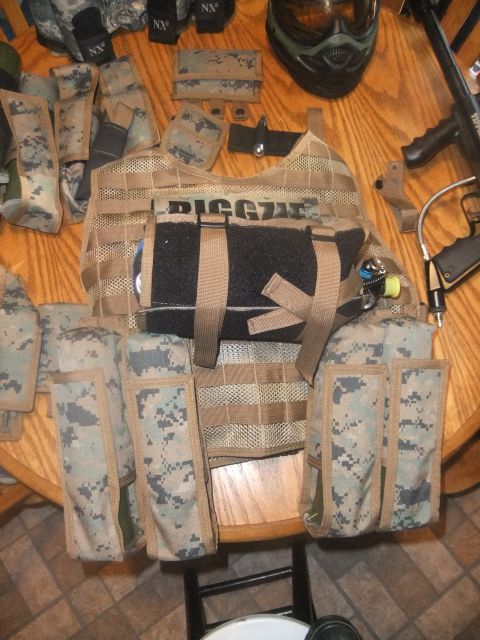 1978 Chevrolet C/K Pickup - Tactical gear, including a vest, mask, and paintball marker, is arranged on a wooden surface.