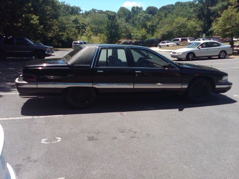 1991 Ford Crown Victoria LTD - Side view of a black sedan with a vinyl roof, parked in a lot with other vehicles.