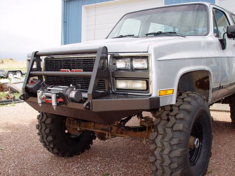 1993 Ford Bronco - This modified SUV features a prominent GMC grille and a heavy-duty winch mounted on the front bumper.