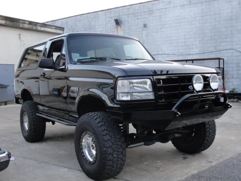 1993 Ford Bronco - Modified 1993 Ford Bronco with custom bumper and auxiliary lights, viewed from a three-quarter front angle.