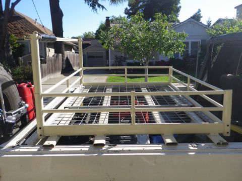 1991 Ford Bronco - A utility rack is installed in the bed of a pickup truck, holding fuel cans and other gear.
