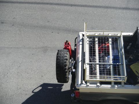 1991 Ford Bronco - Pickup truck bed loaded with a spare tire, jerry can, and cargo cage.