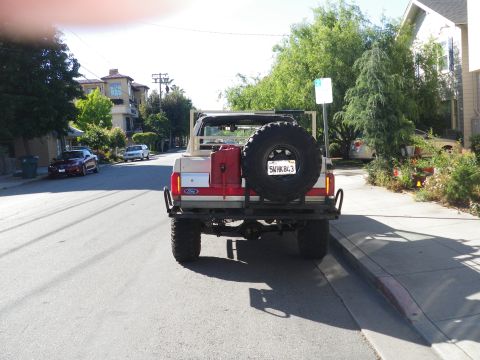 1991 Ford Bronco - This 1991 Ford Bronco is parked on a residential street with a spare tire and a red gas can mounted on the rear.