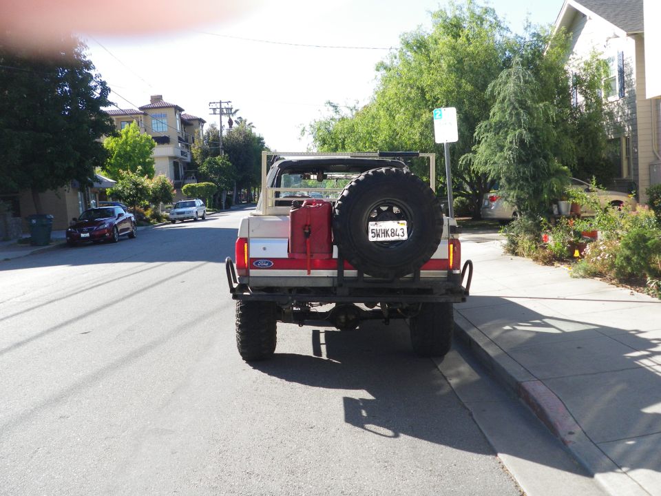 Rear view of a 1991 Ford Bronco with a spare tire and gas can mounted on the back