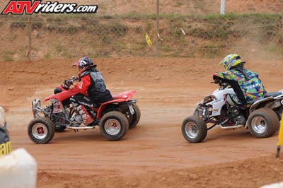 2004 Honda TRX 400 EX - Two ATVs compete on a dirt track, with riders wearing helmets and protective gear.
