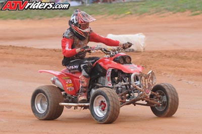 2004 Honda TRX 400 EX - A rider in full gear navigates a dirt track on a red 2004 Honda TRX 400 EX ATV.