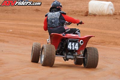 2004 Honda TRX 400 EX - A rider on a red ATV with the number 414 navigates a dirt track.