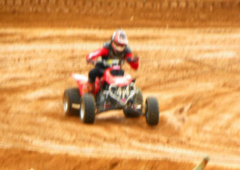 2004 Honda TRX 400 EX - An ATV rider navigates a dirt track, kicking up dust as they go.