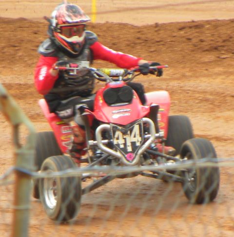 2004 Honda TRX 400 EX - Rider on a red ATV navigates a dirt track, displaying the number 414.
