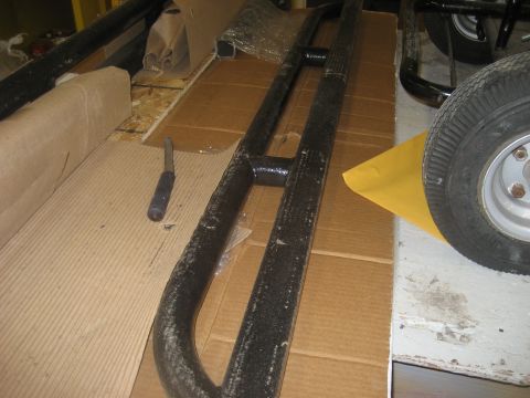 1978 Ford Bronco - Off-road step bars are shown on a cardboard surface with a screwdriver and a wheel in the background.
