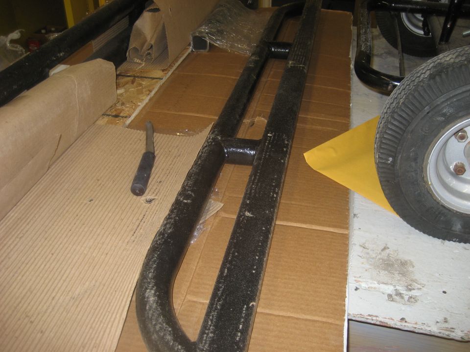 Pair of black off-road step bars with a screwdriver nearby