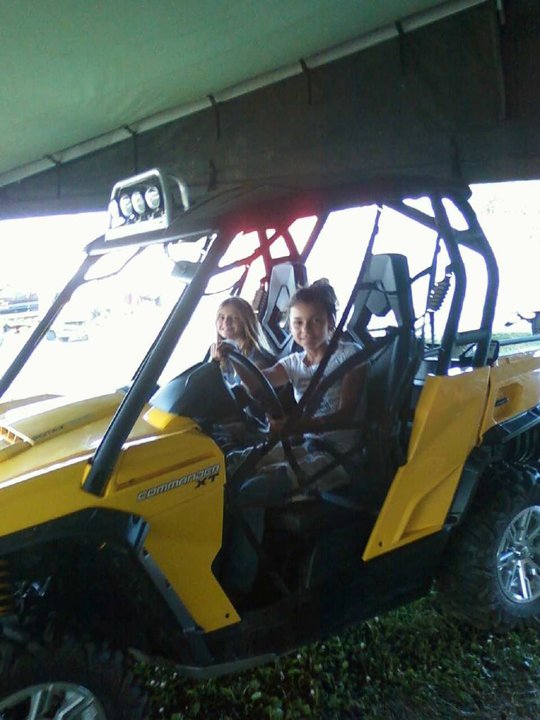 Yellow side-by-side vehicle with two girls in the front seats