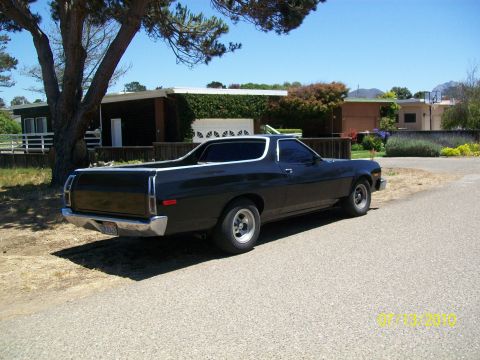 1973 Ford Ranchero - A dark-colored Ford Ranchero is parked on a residential street on a sunny day.