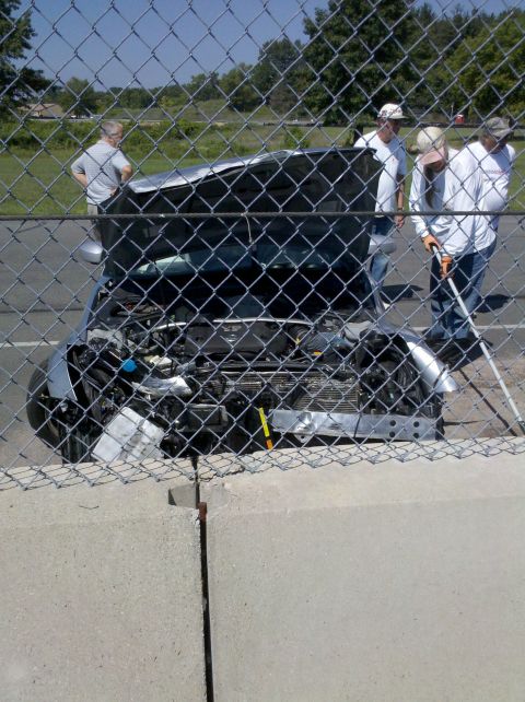 1993 Ford Taurus - A car with its hood open, revealing the engine, is viewed through a chain-link fence.