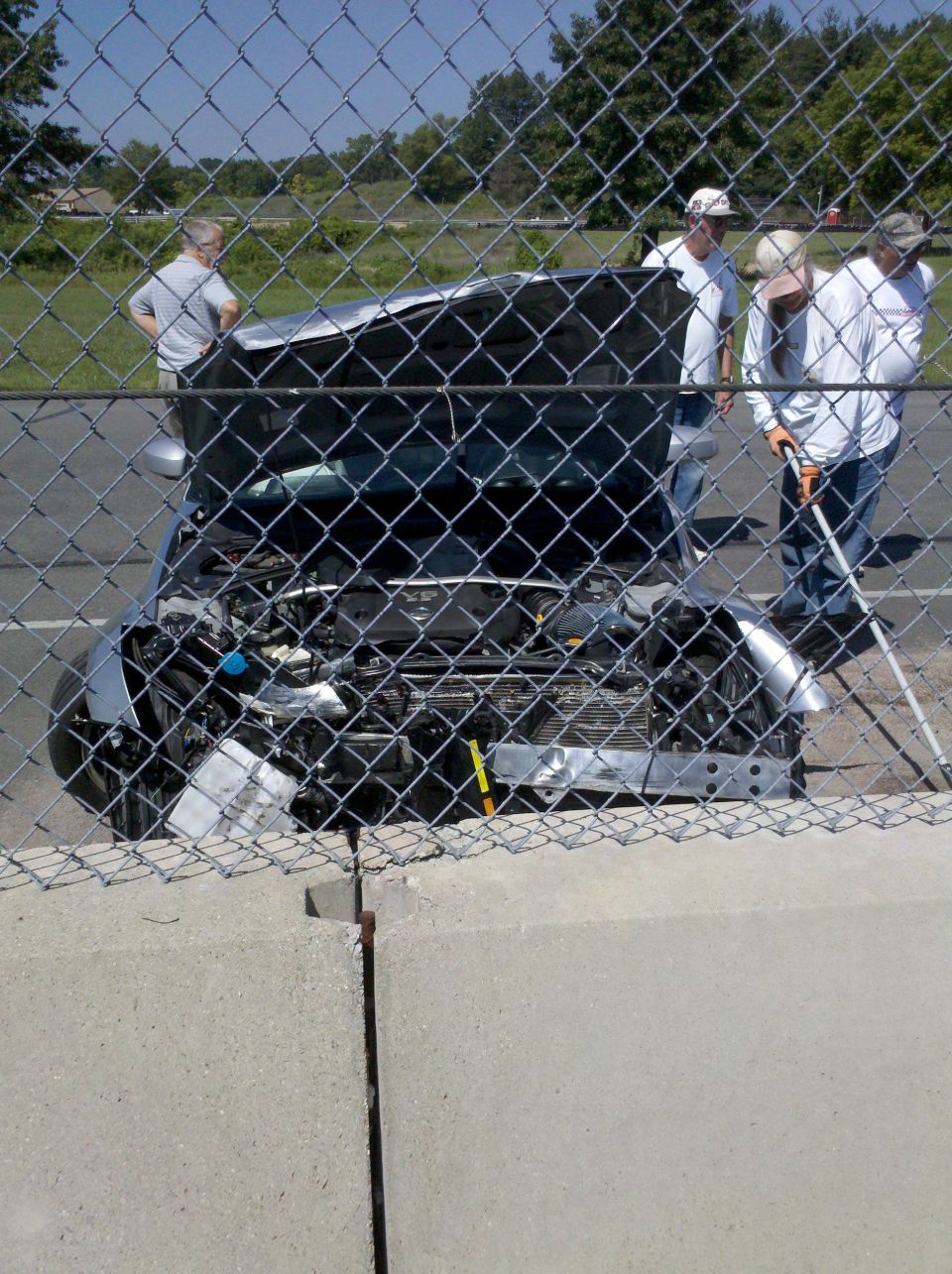 Car with hood open, showing engine compartment, viewed from front