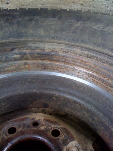 1995 Ford Bronco - This is a close-up view of a rusty wheel and tire, not a 1995 Ford Bronco.