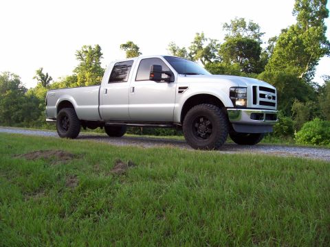 2008 Ford F-250 - A silver 2008 Ford F-250 Super Duty pickup truck is shown from a 3/4 front angle on a gravel road.