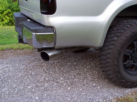 2008 Ford F-250 - The rear of a silver 2008 Ford F-250 pickup truck is visible, a chrome bumper, large exhaust, and tinted taillights.