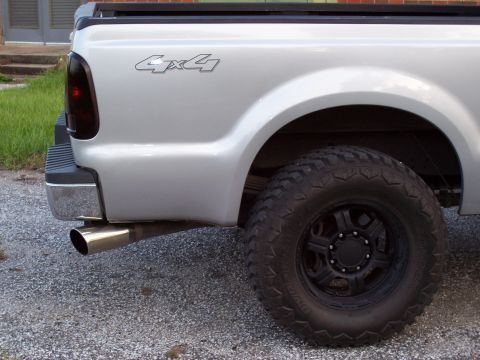 2008 Ford F-250 - Rear quarter panel and wheel of a silver 2008 Ford F-250 pickup truck with a 4x4 badge.