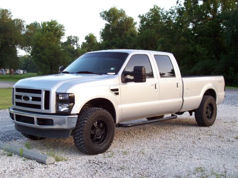 2008 Ford F-250 - A silver 2008 Ford F-250 Super Duty pickup truck is parked on a gravel lot with trees in the background.