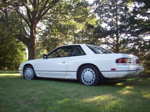 1992 Nissan 240SX - A white coupe is parked on a grassy lawn with trees in the background.