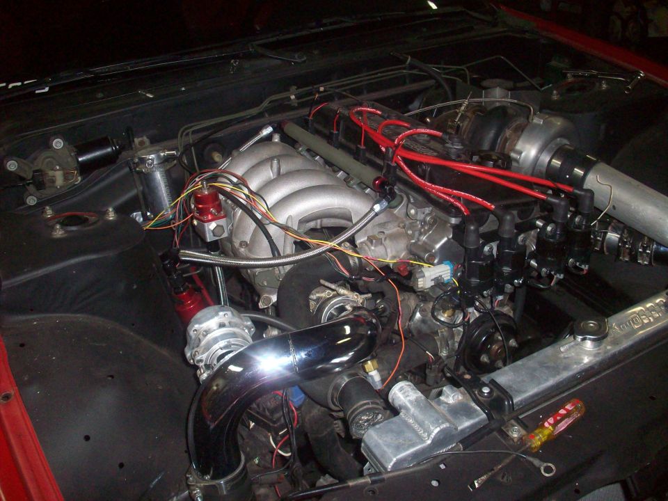 Engine bay with turbocharger, intercooler piping, and fuel pressure regulator