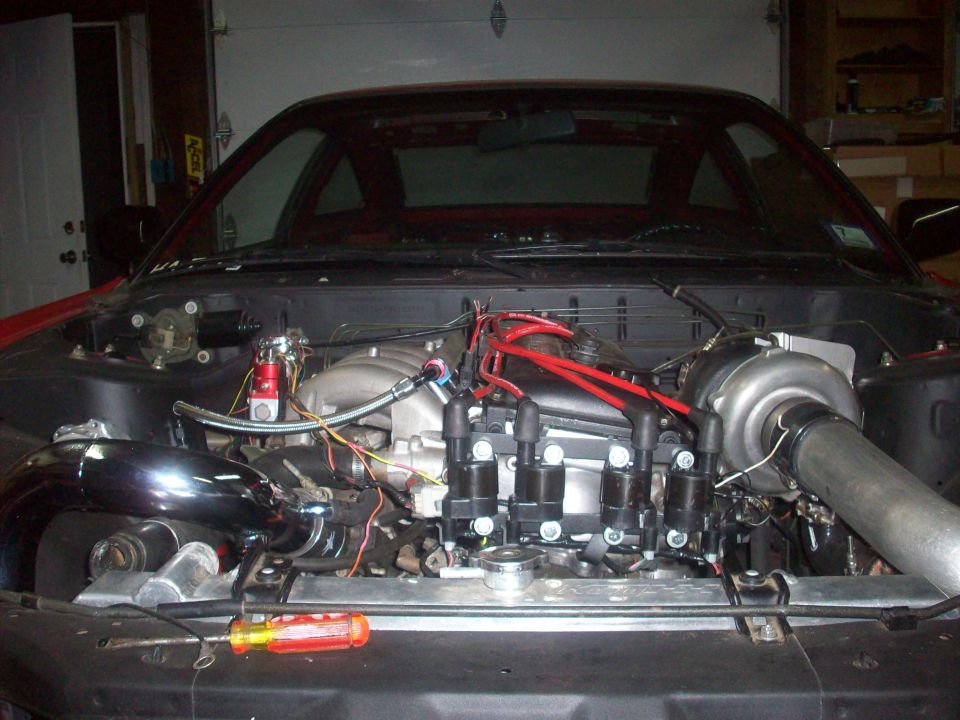 Engine bay with turbocharger and custom piping. Screwdriver on radiator