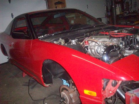 1992 Nissan 240SX - This red 1992 Nissan 240SX coupe is shown with its engine exposed and front fender removed, indicating it is undergoing maintenance or modi…
