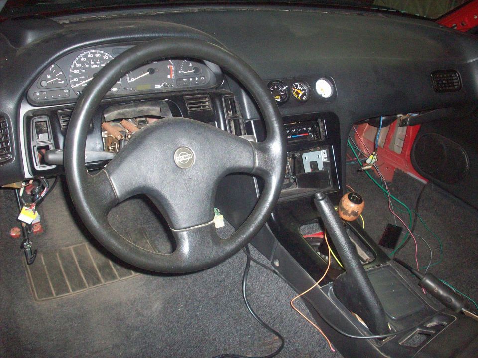 1992 Nissan 240SX interior with aftermarket gauges and a wooden shift knob