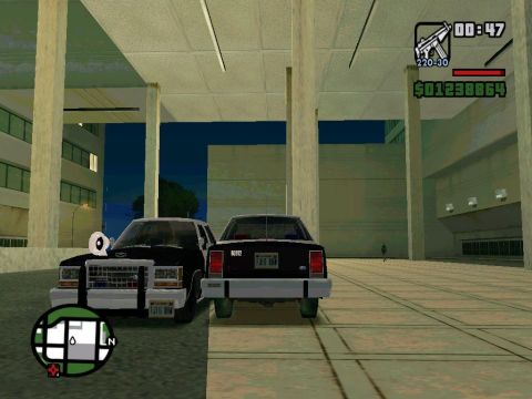 2000 Mercury Grand Marquis - A police car and a sedan are parked in front of a modern building.
