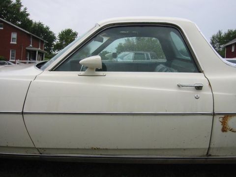 1971 Ford Ranchero - A white Ford Ranchero is seen from the side, with visible rust and chrome trim.