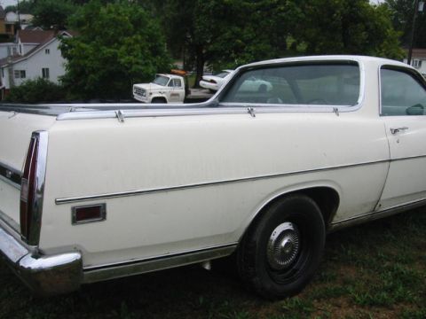 1971 Ford Ranchero - A white pickup truck is parked in front of another vehicle.