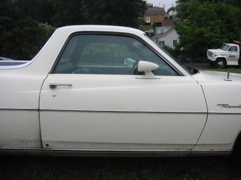1971 Ford Ranchero - A white 1971 Ford Ranchero is seen from the side, with a white truck in the background.