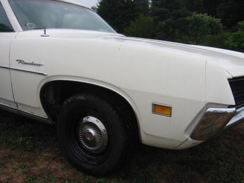 1971 Ford Ranchero - Close-up of a white Ford Ranchero's front fender and bumper, showing the side marker light and wheel.