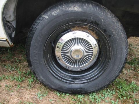 1971 Ford Ranchero - Close-up of a chrome Ford hubcap on a black wheel, likely from a 1971 vehicle.
