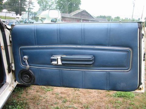 1971 Ford Ranchero - Close-up of a car's interior door panel, blue upholstery and chrome accents.