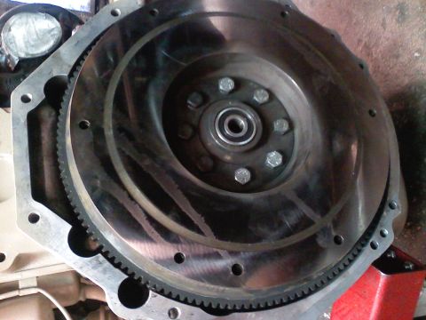 1990 Ford Bronco - Close-up view of a flywheel and transmission bell housing, likely part of an engine modification or repair.