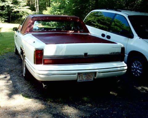 1972 Ford Ranchero - A white Lincoln Ranchero with a maroon top is parked next to a white minivan.
