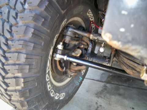 1985 Ford Bronco - Detail of the front suspension and tire assembly, showing the steering components.