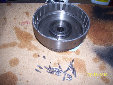 1978 Ford Bronco - A disassembled transmission drum and clutch plates are shown on a workbench, indicating a repair or rebuild process.