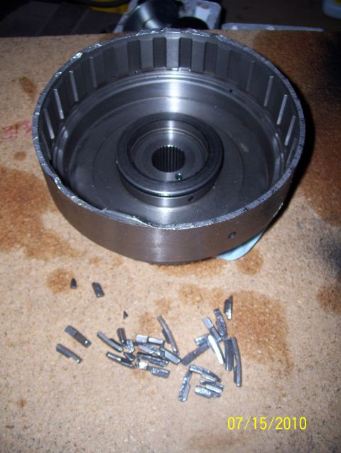 1978 Ford Bronco - A transmission drum and numerous broken pieces are scattered on a wooden surface, with a date stamp of 07/15/2010 visible.